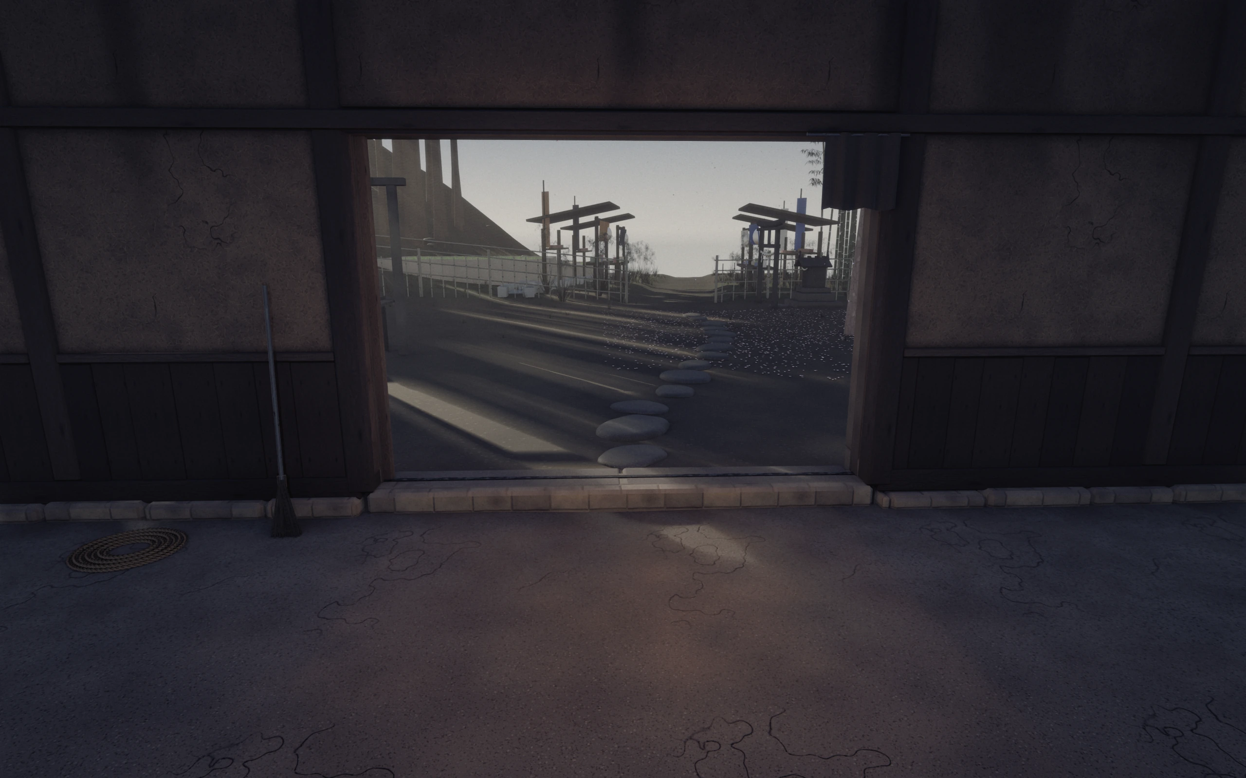 Looking back out of the open forge door at the daylit yard and the drying racks beyond; a pole leans by the frame.
